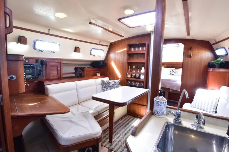 Slide: The Image of Interior of 1999 Island Packet 380 sailboat with cozy seating and wooden cabinetry. - 23