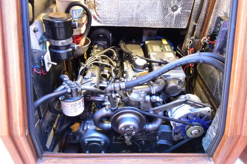 Slide: The Image of Engine compartment of a 1999 Island Packet 380 sailboat, showcasing mechanical components. - 28