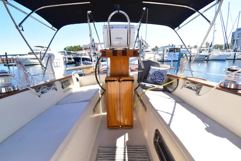 Slide: The Image of Cockpit of 1999 Island Packet 380 sailboat docked at marina, featuring seating and helm. - 29