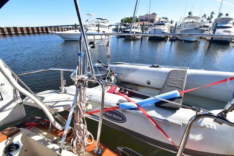 Slide: The Image of Docked Island Packet 380 sailboat with inflatable dinghy, 1999 model, in a marina setting. - 5