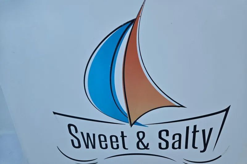 Slide: The Image of Logo of "Sweet & Salty" with stylized blue and orange sails, Fountaine Pajot Helia 44 Evolution. - 42