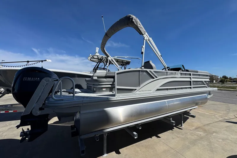 Slide: The Image of 2026 Bennington 22 SSB pontoon boat with Yamaha engine, docked under clear blue sky. - 2