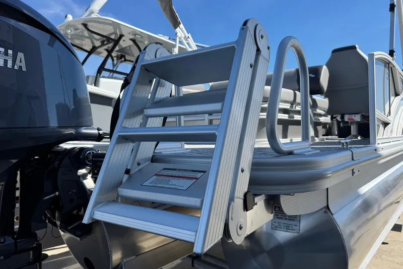 Slide: The Image of 2026 Bennington 22 SSB pontoon boat with ladder and Yamaha engine, under clear blue sky. - 3