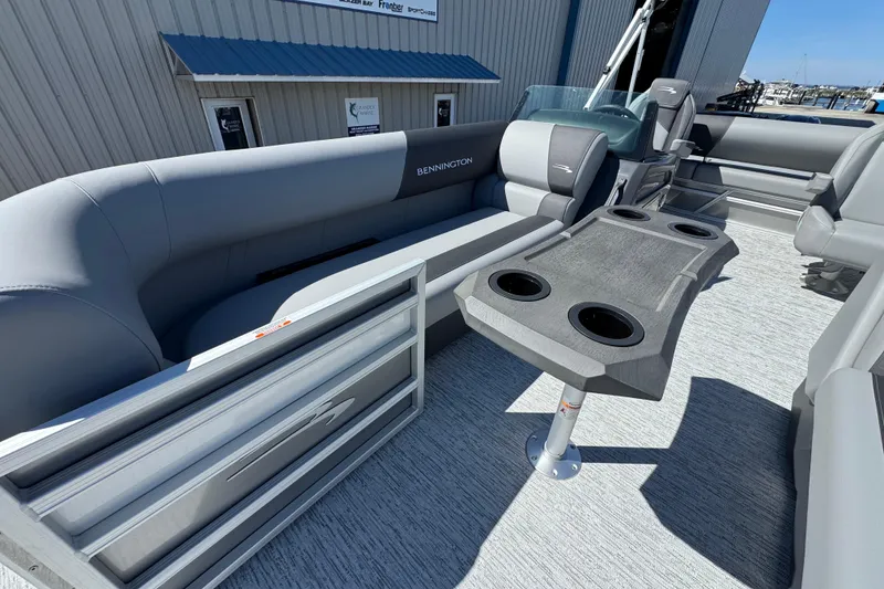 Slide: The Image of 2026 Bennington 22 SSB pontoon boat interior with gray seating and cupholder table. - 8