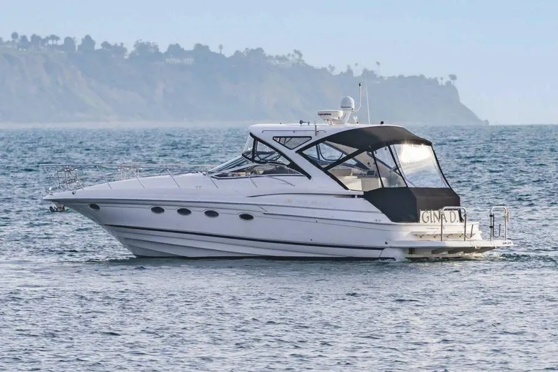 Slide: The Image of 2010 Regal Commodore 4460 yacht cruising on the ocean near a scenic coastline. - 10