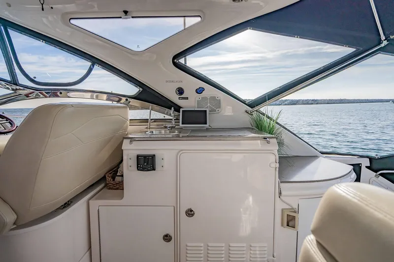 Slide: The Image of Interior view of a 2010 Regal Commodore 4460 yacht with luxurious seating and ocean backdrop. - 24