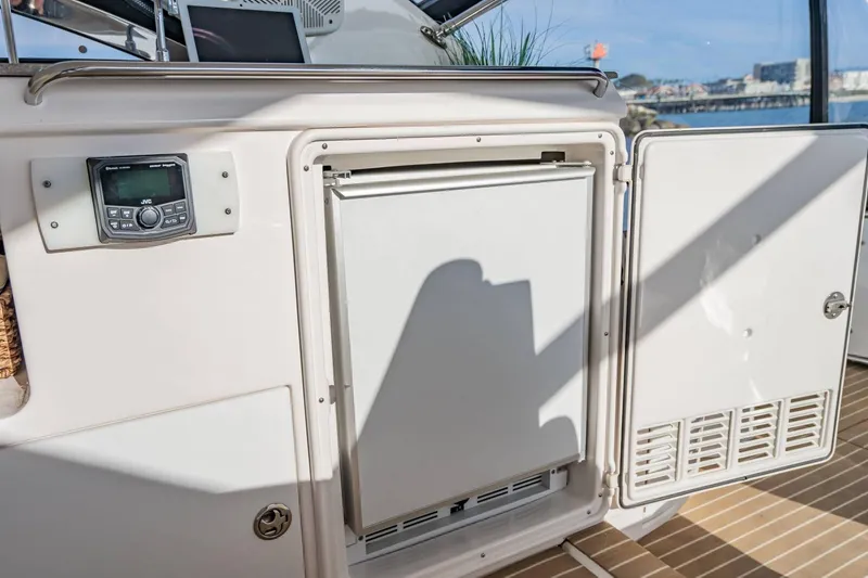 Slide: The Image of 2010 Regal Commodore 4460 yacht interior with open storage compartment and control panel. - 25