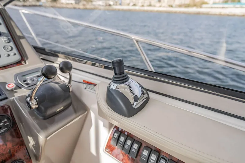 Slide: The Image of Control panel of a 2010 Regal Commodore 4460 yacht with joystick and throttle levers. - 34