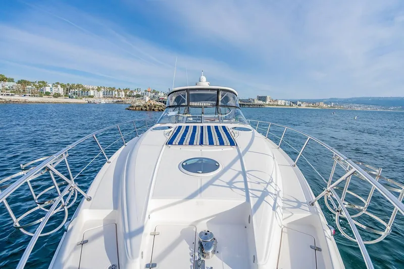 Slide: The Image of 2010 Regal Commodore 4460 yacht cruising near coastal cityscape. - 40