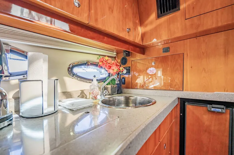 Slide: The Image of Luxurious 2010 Regal Commodore 4460 yacht kitchen with wood cabinetry and modern amenities. - 49