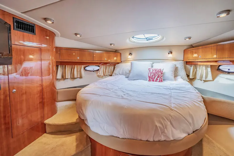 Slide: The Image of Luxurious bedroom interior of 2010 Regal Commodore 4460 yacht with plush bedding and wood accents. - 54