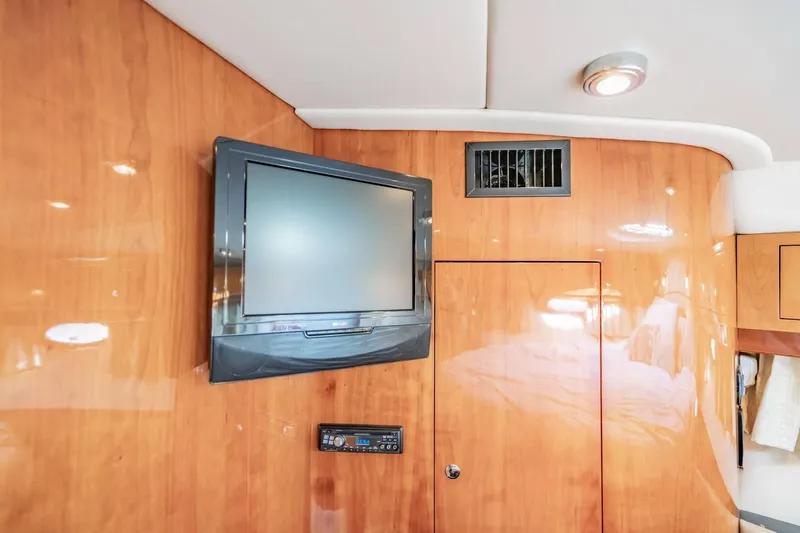 Slide: The Image of Flat-screen TV and control panel on Regal Commodore 4460 yacht's wooden interior wall. - 56