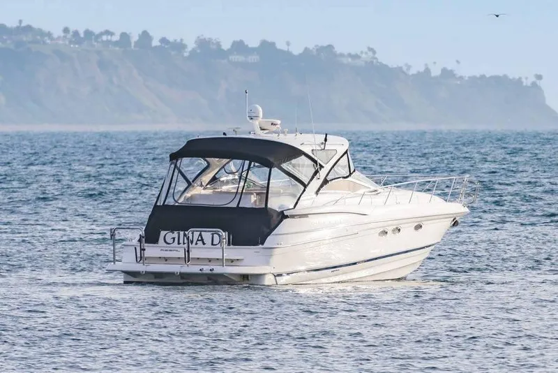 Slide: The Image of 2010 Regal Commodore 4460 yacht cruising on ocean with scenic coastal backdrop. - 7