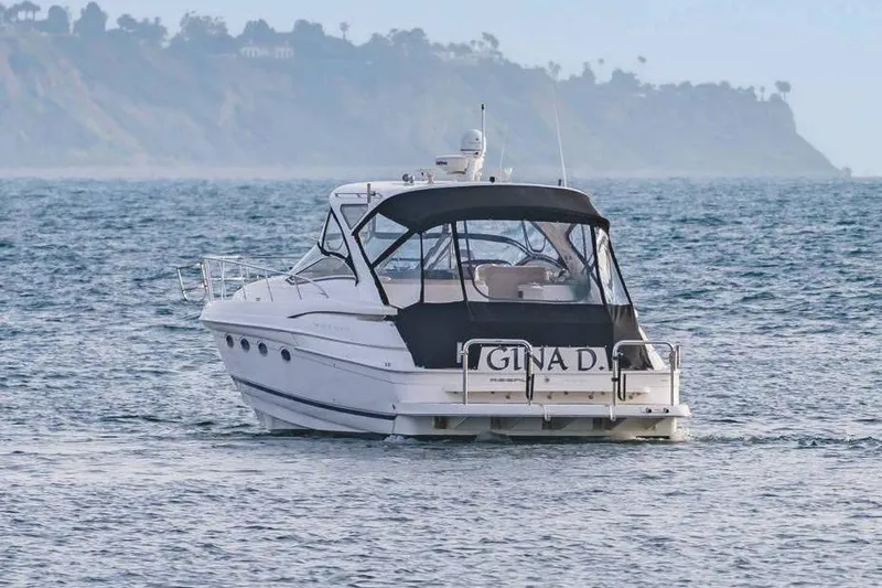 Slide: The Image of 2010 Regal Commodore 4460 yacht cruising on the ocean with scenic coastline backdrop. - 9