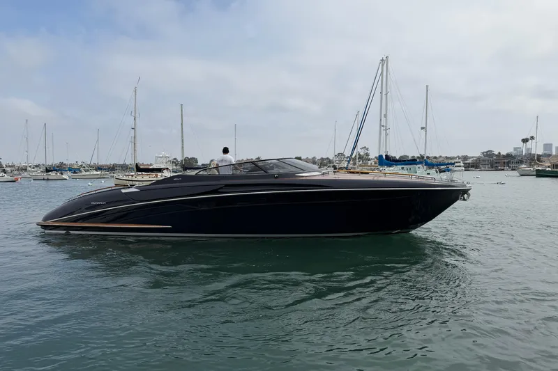 Slide: The Image of 2012 Riva 44' Rivarama luxury yacht cruising in a marina with sailboats. - 2