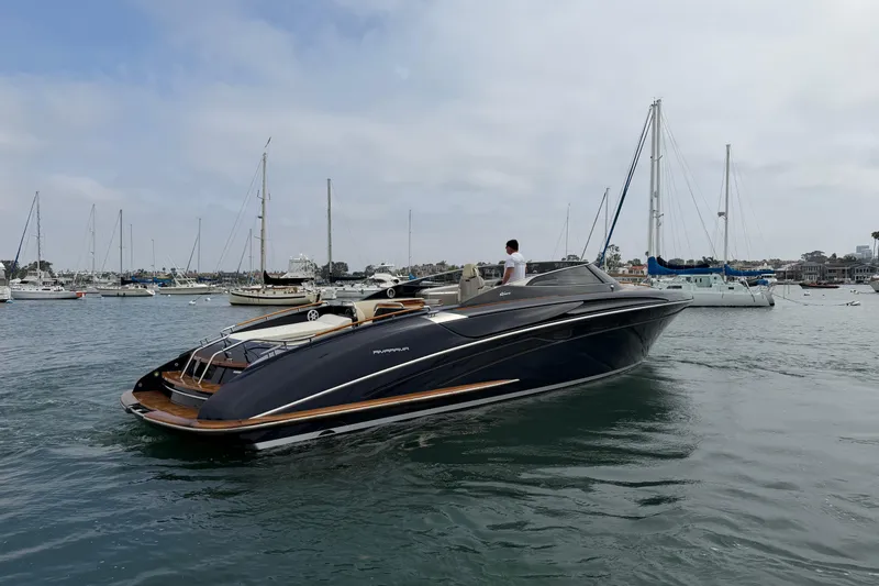 Slide: The Image of 2012 Riva 44' Rivarama luxury yacht cruising in a marina with sailboats. - 3