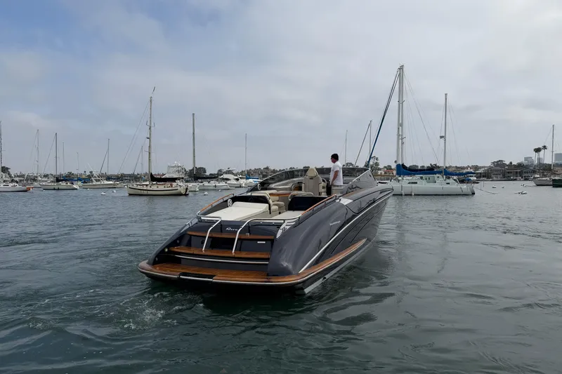 Slide: The Image of 2012 Riva 44' Rivarama luxury yacht cruising in a marina with sailboats. - 4