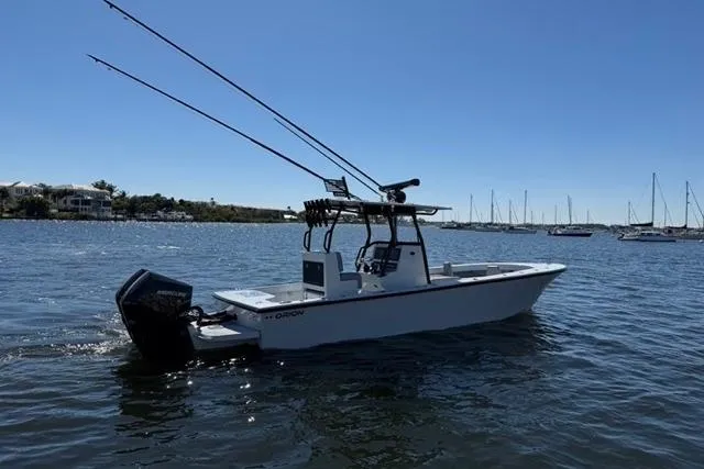 The Image of 2026 Orion 29 boat on calm water with fishing rods and outboard motor. - 0