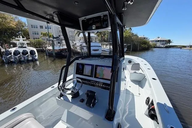 Slide: The Image of Modern Orion 29 boat cockpit with advanced navigation systems, docked near waterfront homes, 2026 model. - 12