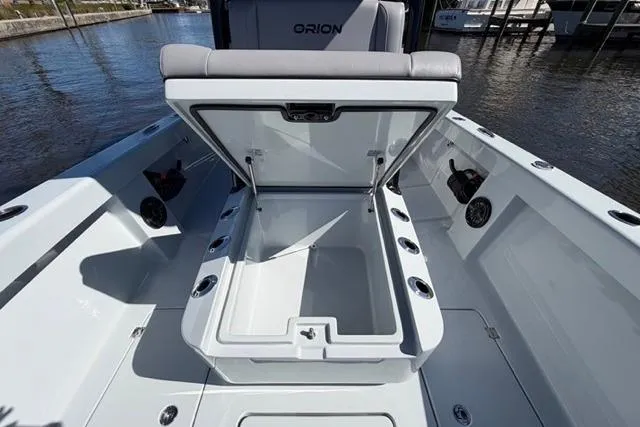 Slide: The Image of Open storage compartment on 2026 Orion 29 boat, docked by the water. - 2