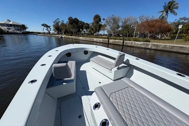 Slide: The Image of 2026 Orion 29 boat with sleek seating, docked by a scenic waterfront. - 3