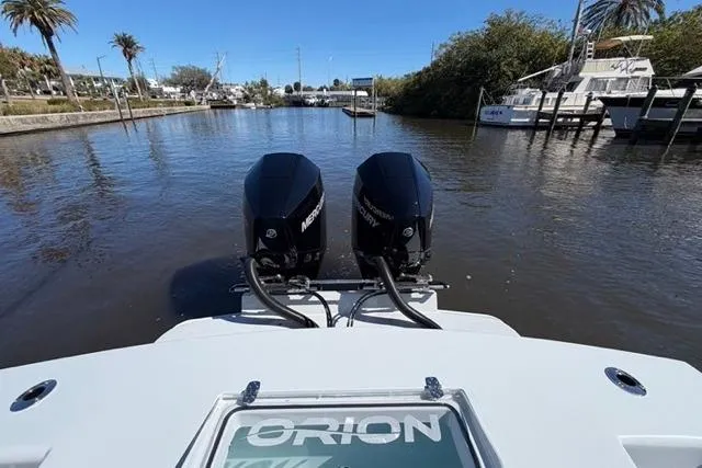 Slide: The Image of Twin Mercury engines on a 2026 Orion 29 boat, docked in a serene marina. - 4