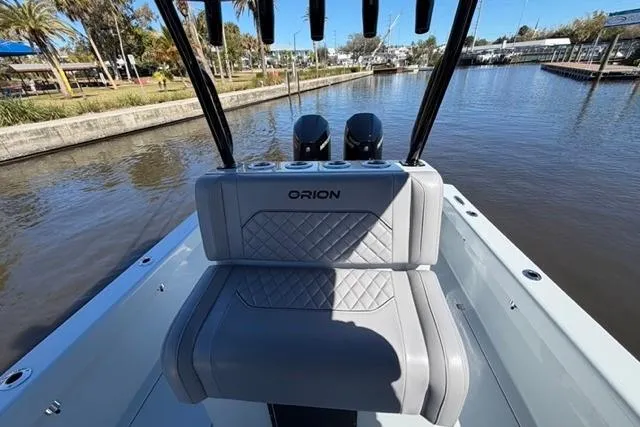 Slide: The Image of 2026 Orion 29 boat with sleek seating, docked by a scenic waterfront. - 8