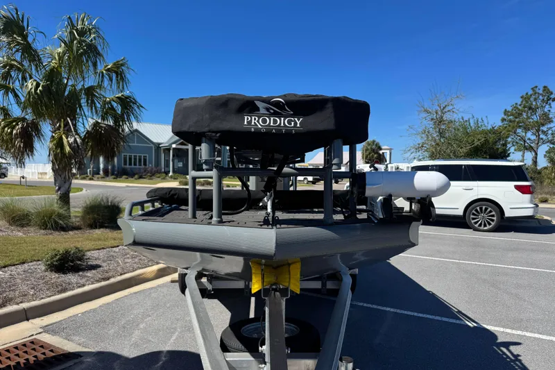 Slide: The Image of Boat trailer with Prodigy 1960 Marsh Tuff, parked near palm trees and vehicles. - 15
