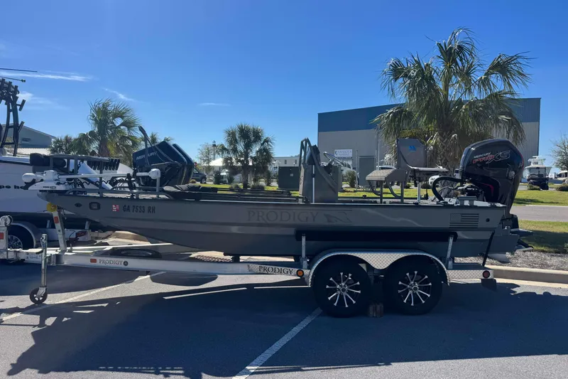 Slide: The Image of 2024 Prodigy 1960 Marsh Tuff boat on trailer, parked outdoors under clear sky. - 3