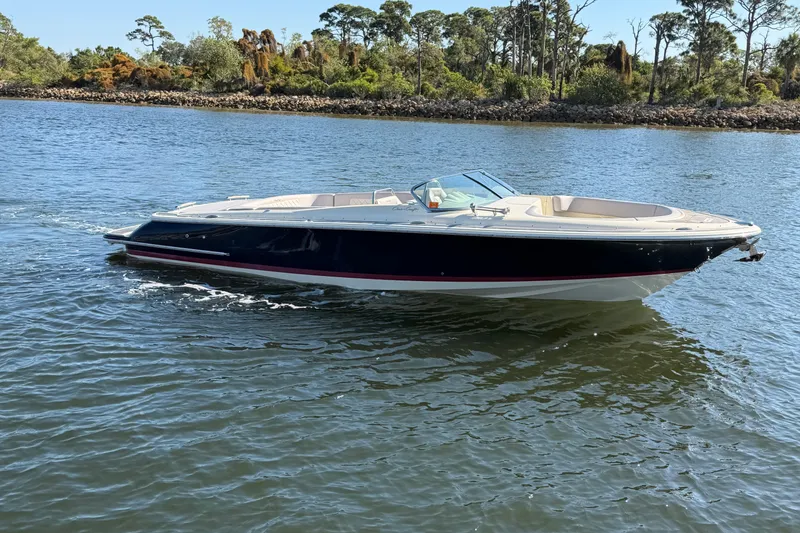 The Image of 2019 Chris-Craft Launch 30 boat cruising on a scenic waterway. - 0