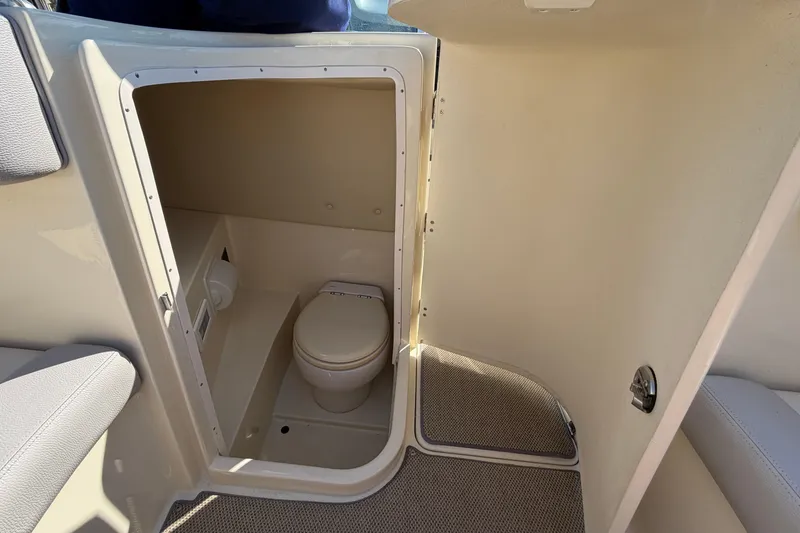Slide: The Image of Interior view of 2019 Chris-Craft Launch 30 boat bathroom with toilet and beige walls. - 11