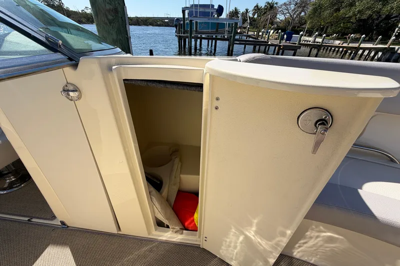 Slide: The Image of 2019 Chris-Craft Launch 30 boat storage compartment with open door, revealing life jackets inside. - 14