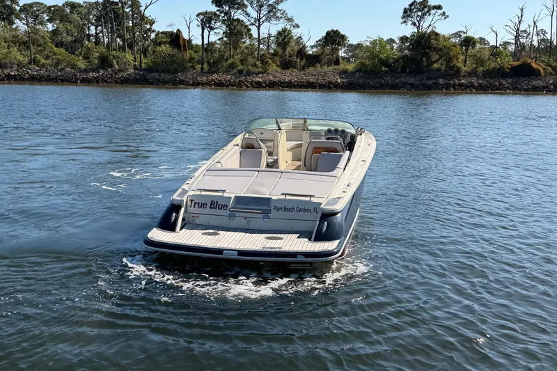 Slide: The Image of 2019 Chris-Craft Launch 30 boat on water, rear view, with scenic background. - 4
