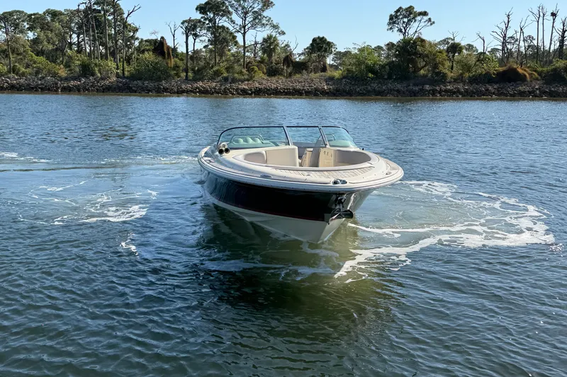 Slide: The Image of 2019 Chris-Craft Launch 30 boat cruising on a serene waterway with lush greenery. - 5