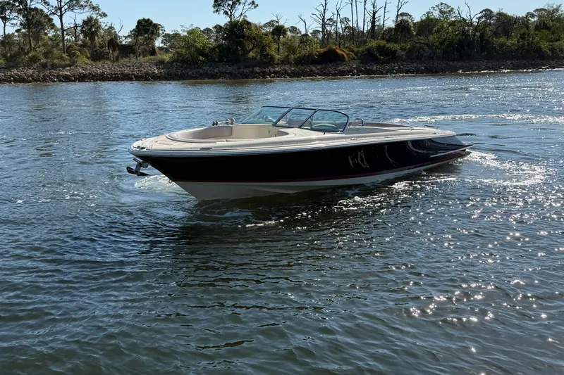 Slide: The Image of 2019 Chris-Craft Launch 30 boat cruising on a sunny lake with scenic background. - 7
