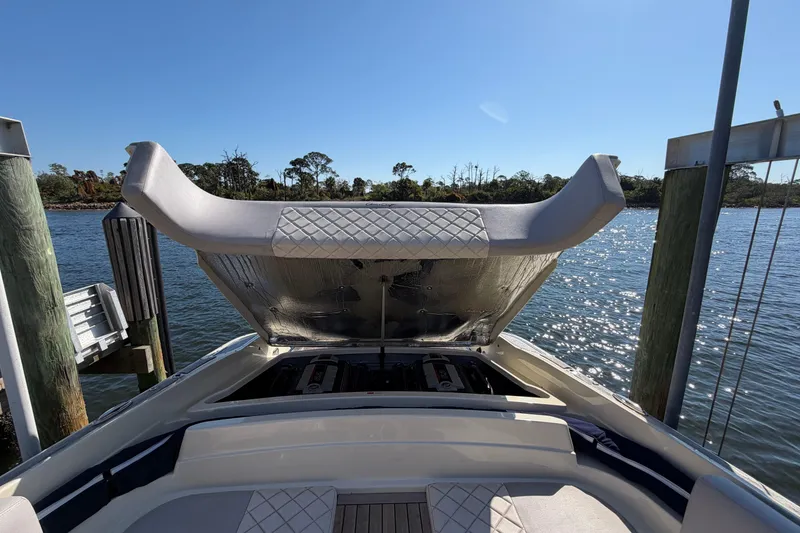Slide: The Image of 2019 Chris-Craft Launch 30 boat with open engine compartment, docked by a scenic waterfront. - 9