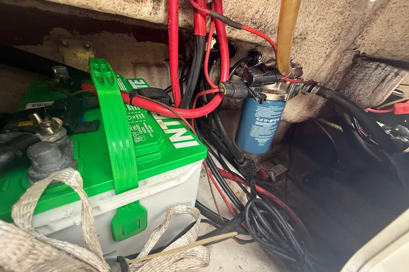 Slide: The Image of Battery compartment of a 2005 Sea Hunt Triton 232 boat with wiring and components. - 12