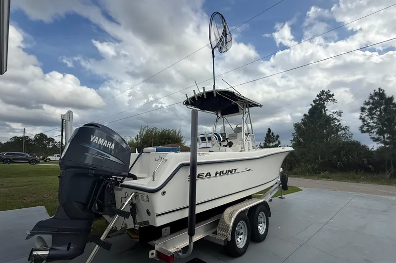 Slide: The Image of 2005 Sea Hunt Triton 232 boat on trailer with Yamaha outboard motor, parked outdoors. - 3