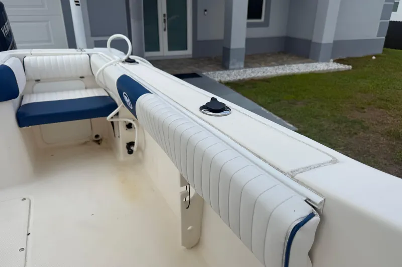 Slide: The Image of 2005 Sea Hunt Triton 232 boat with T-top, parked on driveway, overcast sky. - 34