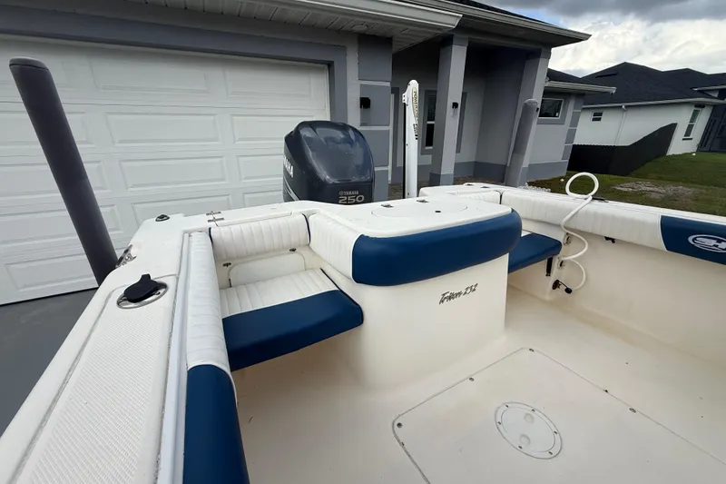 Slide: The Image of 2005 Sea Hunt Triton 232 boat interior with cushioned seating under cloudy sky. - 35