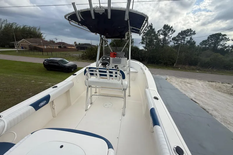 Slide: The Image of 2005 Sea Hunt Triton 232 boat with blue and white seating, under cloudy sky. - 36