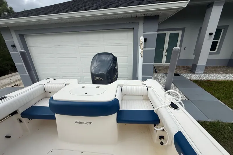 Slide: The Image of 2005 Sea Hunt Triton 232 boat storage compartment with open lid and cushioned seating. - 6