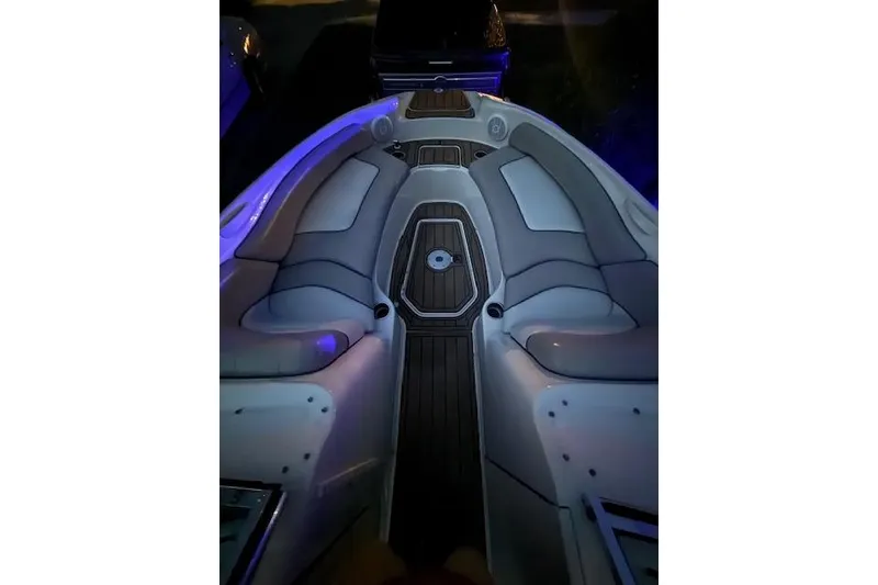 Slide: The Image of 2003 Sea Ray 240 Sundeck interior with cushioned seating and wood-style flooring. - 11