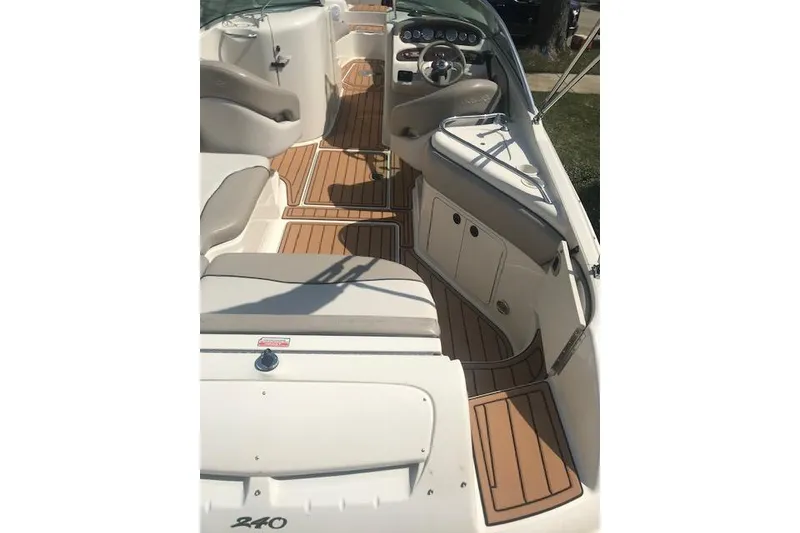 Slide: The Image of 2003 Sea Ray 240 Sundeck interior with beige seating and wood-style flooring. - 4