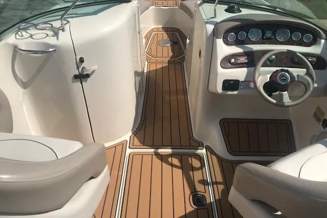 Slide: The Image of 2003 Sea Ray 240 Sundeck interior with wood flooring and steering console. - 5