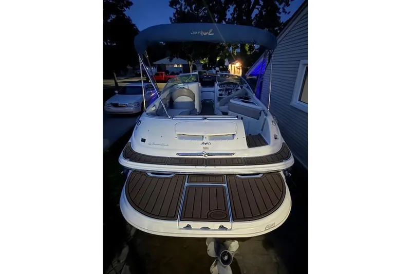 Slide: The Image of 2003 Sea Ray 240 Sundeck boat with blue canopy, parked at night. - 9