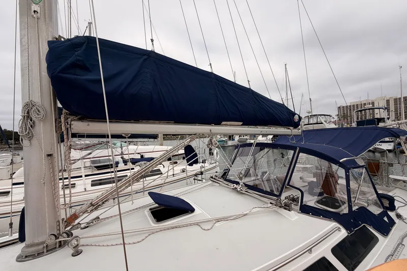 Slide: The Image of 1996 Catalina 36 MkII sailboat with blue canvas cover docked at marina. - 10