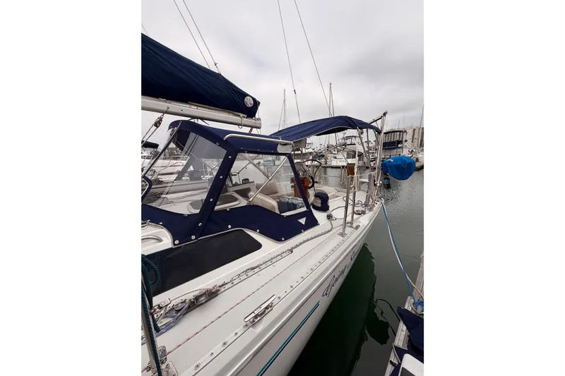 Slide: The Image of 1996 Catalina 36 MkII sailboat docked in marina, featuring blue canopy and sleek design. - 11