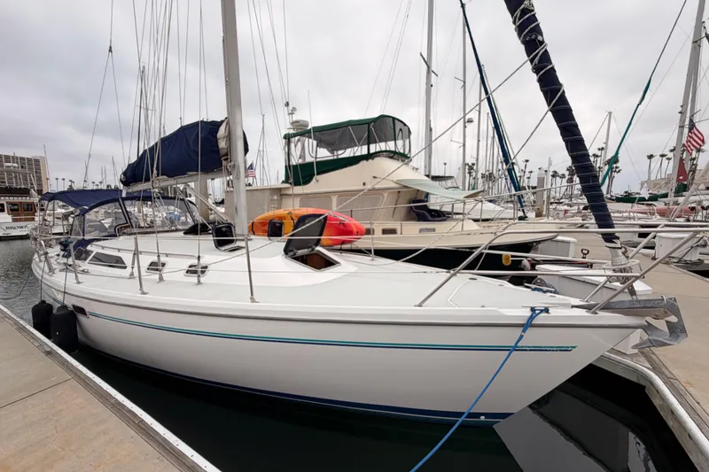 Slide: The Image of 1996 Catalina 36 MkII sailboat docked at marina, featuring sleek design and blue accents. - 2