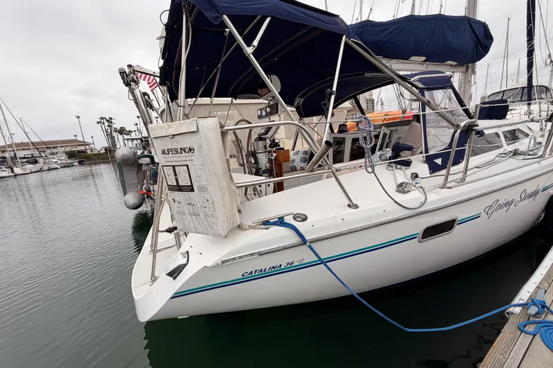 Slide: The Image of 1996 Catalina 36 MkII sailboat docked in marina with blue canopy and lifebuoy. - 3
